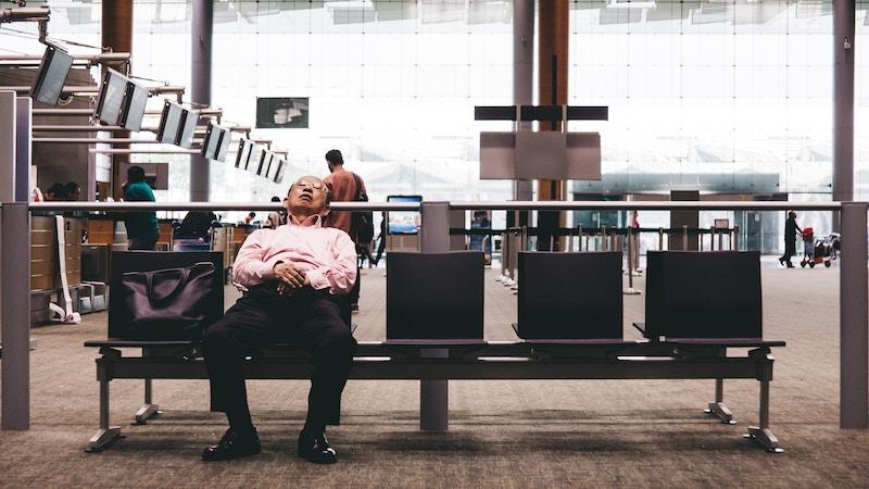 Homme qui dort à l'aéroport